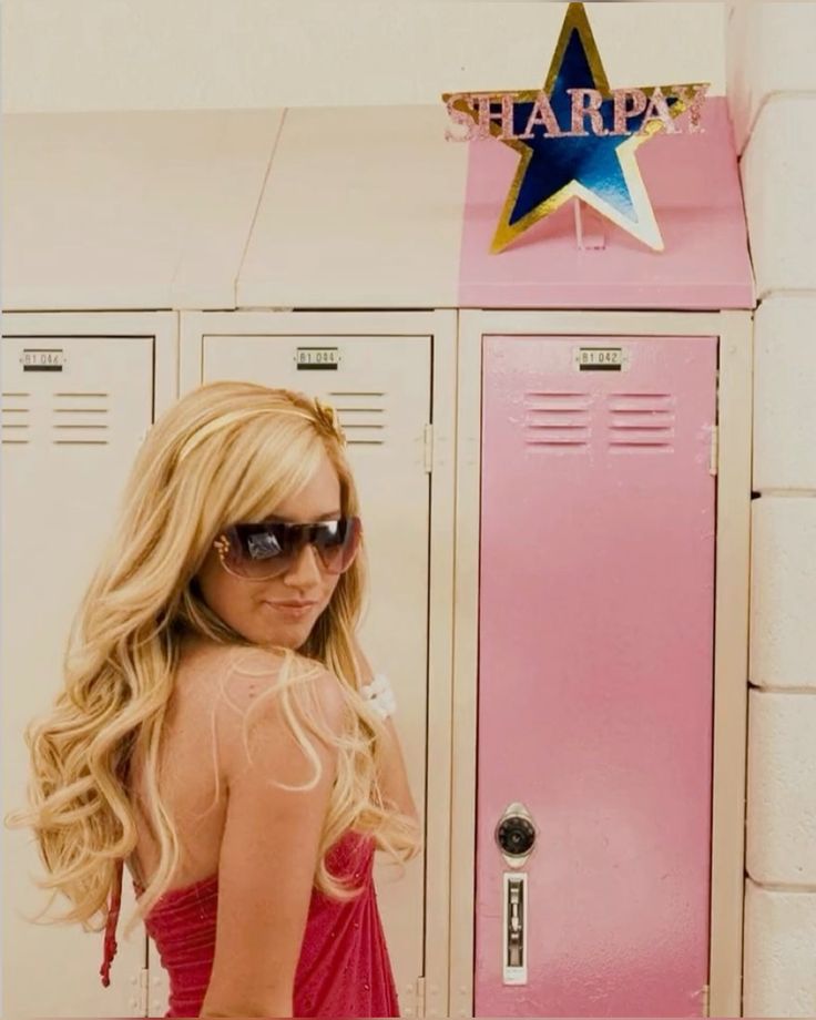 Mujer glamorosa frente a un locker rosa